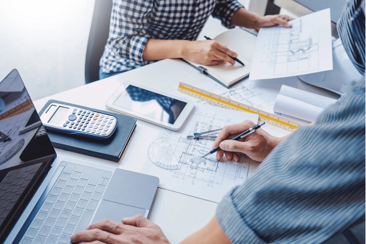 Moon Matz engineers working at desk with blueprints